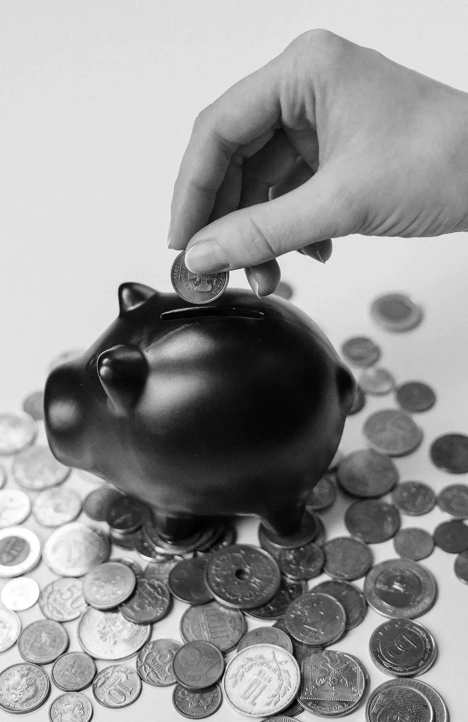 coins being deposited into a piggy bank